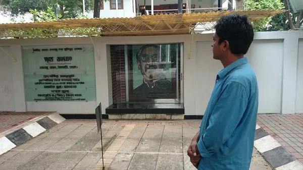 একজন ব্যক্তি ভার্চুয়াল বঙ্গবন্ধুর ছবি দেখছেন. Channel i News - চ্যানেল আই নিউজ