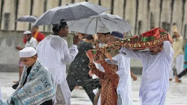 বৃষ্টির মধ্যে ঈদ উদযাপন করছে মুসল্লিরা, ছাতা ব্যবহার করে।. Channel i News - চ্যানেল আই নিউজ