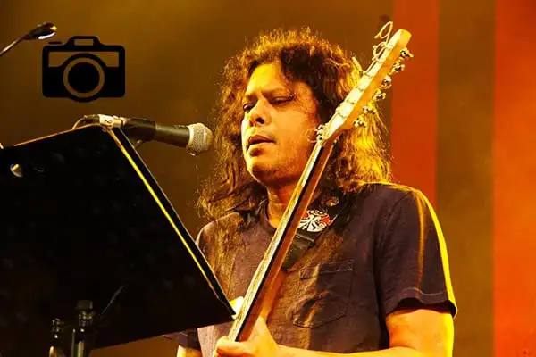 গানপ্রেমী মানুষ একটি গিটার বাজাচ্ছেন, মঞ্চে পরিবেশনা করছেন. Channel i News - চ্যানেল আই নিউজ