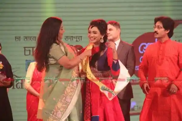 নুসরাত সায়েমের হাতে পুরস্কার তুলে দিচ্ছেন অন্য একজন. Channel i News - চ্যানেল আই নিউজ
