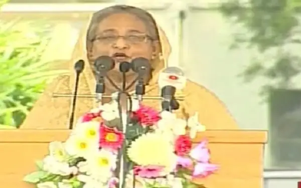 প্রধানমন্ত্রী ভাষণ দিচ্ছেন, পেছনে সবুজ গাছের পটভূমি. Channel i News - চ্যানেল আই নিউজ