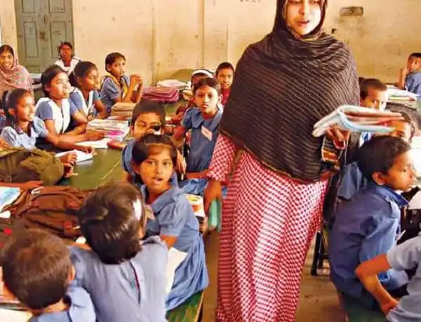 প্রাথমিক বিদ্যালয়ে শিক্ষার্থী ও শিক্ষিকা ক্লাসে শিক্ষাদান করছেন. Channel i News - চ্যানেল আই নিউজ