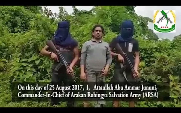 Rohingya militants with guns and a man in the middle in a forested area. Channel i News - চ্যানেল আই নিউজ
