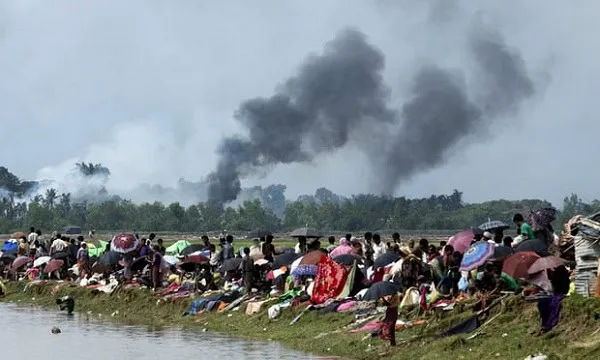 জনসমাগমের পাশে ধোঁয়া উড়ছে, দূরে বনাঞ্চল ও আকাশ. Channel i News - চ্যানেল আই নিউজ