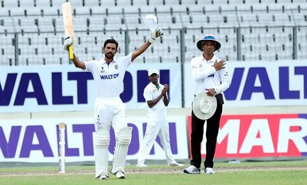 বাংলাদেশি ক্রিকেটার মার্শাল সেঞ্চুরি উদযাপন করছেন, মাঠে দর্শকরা দেখছেন. Channel i News - চ্যানেল আই নিউজ