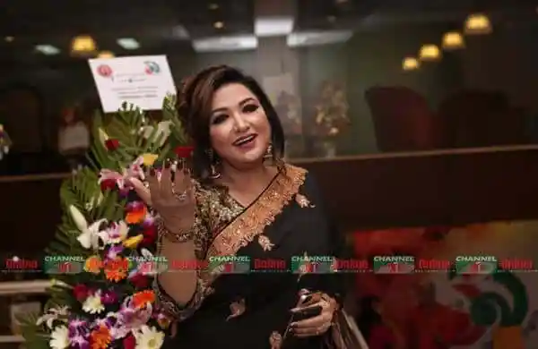 মিতালী মুখার্জি গান শুনতে আসা এক মহিলার ছবি, ফুলের তোড়া হাতে. Channel i News - চ্যানেল আই নিউজ