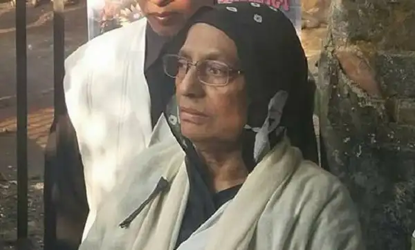 শহীদ মিলনের মা, চোখে অশ্রু, শান্ত ও দুঃখিত মুখে দাঁড়িয়ে. Channel i News - চ্যানেল আই নিউজ