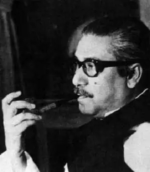 বঙ্গবন্ধু শেখ মুজিবুর রহমানের কালো-সাদা ছবি, চশমা পরা, ধূমপান করছেন. Channel i News - চ্যানেল আই নিউজ