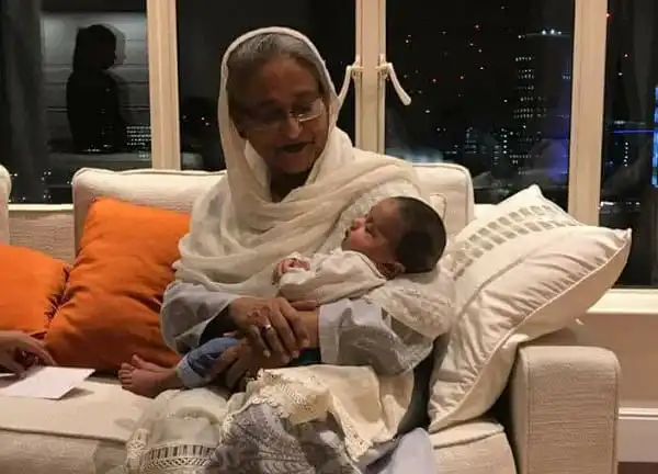 বৃদ্ধা নারী শিশুকে আদর করছেন, ঘরে বসে রাতের দৃশ্য. Channel i News - চ্যানেল আই নিউজ