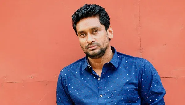 ইশতিয়াক আহমেদ, বাংলাদেশি লেখক ও সাংবাদিক, পটভূমিতে লাল দেয়াল. Channel i News - চ্যানেল আই নিউজ
