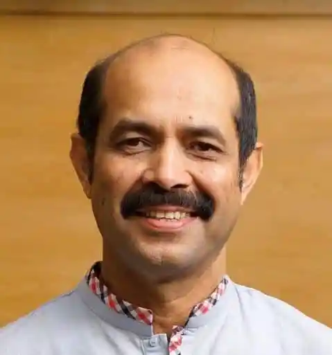 Bangladeshi man with mustache smiling in a professional setting. Channel i News - চ্যানেল আই নিউজ