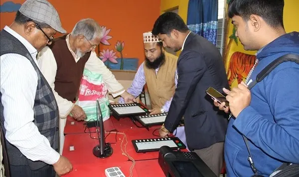 Bangladeshi officials and journalists examine electronic voting machines at a press event. Channel i News - চ্যানেল আই নিউজ