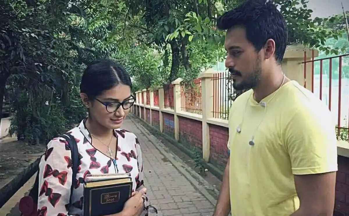 দুজন তরুণ ব্যক্তি একে অপরের সাথে কথা বলছেন, একজনের হাতে বই ও অন্যজনের হাতে ব্যাগ. Channel i News - চ্যানেল আই নিউজ