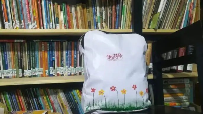 নির্মিত বিদ্যানন্দের স্কুলব্যাগ, বইয়ের শেলফের সামনে. Channel i News - চ্যানেল আই নিউজ