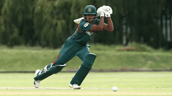 Cricket player in action during a match on a green field. Channel i News - চ্যানেল আই নিউজ