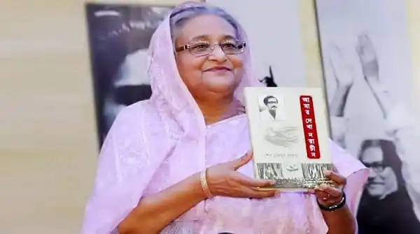 বাংলাদেশের একজন নারী সাংবাদিক চ্যানেল আই অনলাইনের জন্য বই হাতে ধরে হাসছেন।. Channel i News - চ্যানেল আই নিউজ