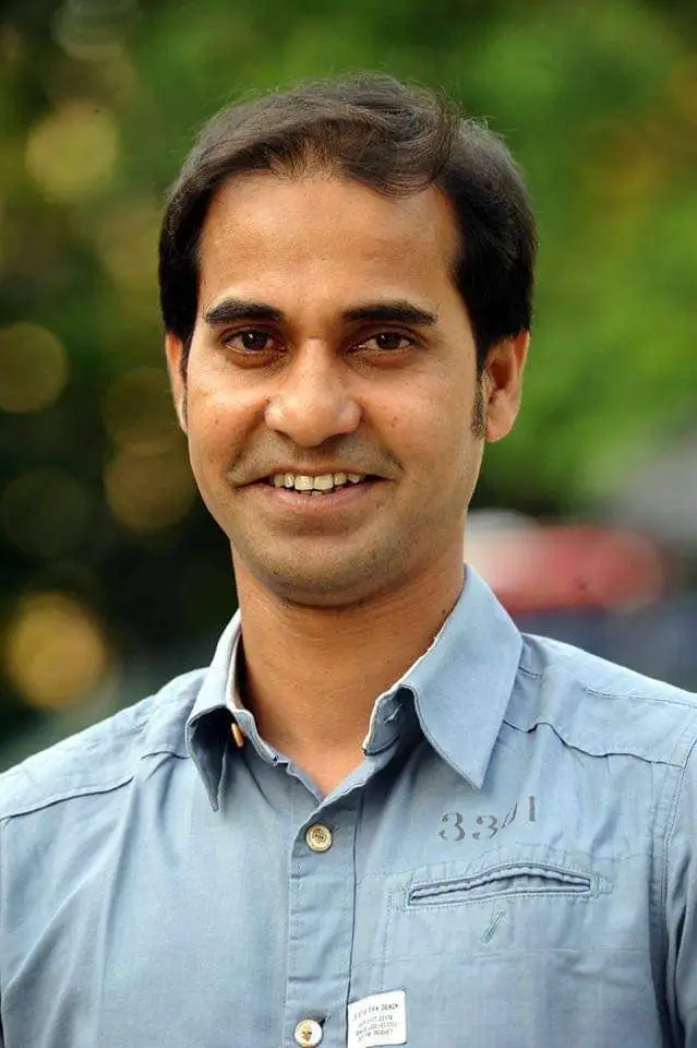 প্রফুল্ল মুখার্জী হাসিমুখে, সবুজ প্রাকৃতিক পটভূমিতে. Channel i News - চ্যানেল আই নিউজ