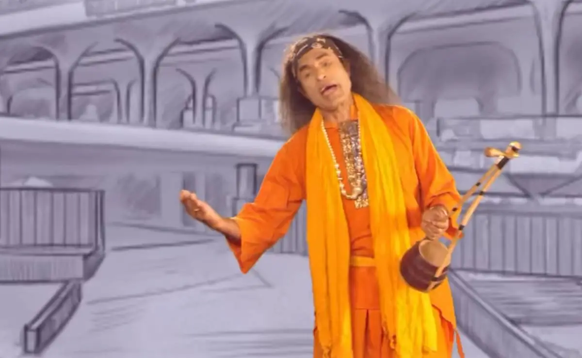 কুদ্দুস বয়াতি গান পরিবেশন করছেন, ব্যাকগ্রাউন্ডে রেলওয়ে স্টেশন দৃশ্য।. Channel i News - চ্যানেল আই নিউজ
