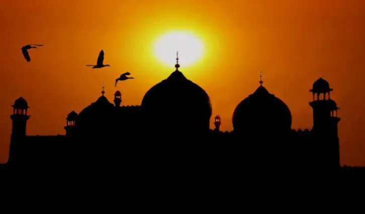 সন্ধ্যায় সূর্যাস্তের সময় মসজিদের silhouette এবং পাখির উড়ান. Channel i News - চ্যানেল আই নিউজ