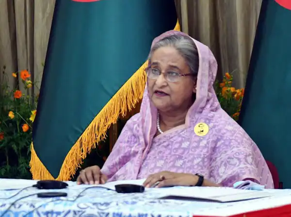 বাংলাদেশের প্রধানমন্ত্রী শেখ হাসিনা জাতীয় পতাকার পাশে বসে আলোচনা করছেন।. Channel i News - চ্যানেল আই নিউজ