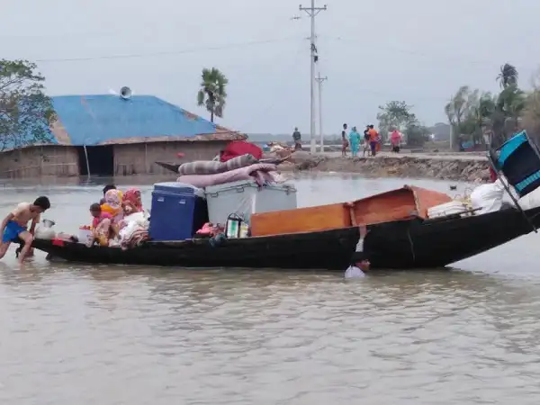 উপকূলীয় এলাকায় ঝড়ের কারণে নৌকা ও মানুষজনের ছবি. Channel i News - চ্যানেল আই নিউজ