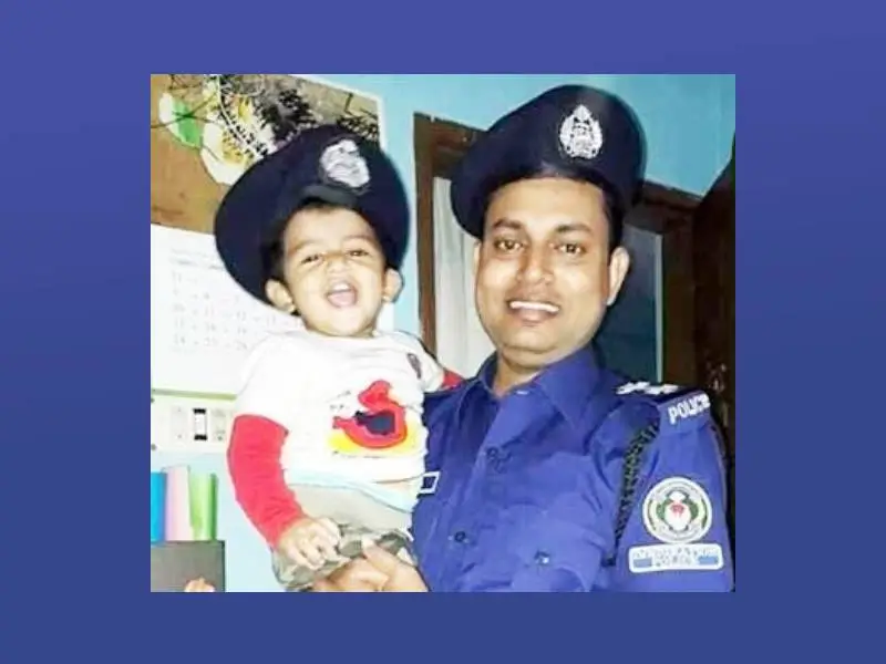 একজন পুলিশ কর্মকর্তা শিশুর সঙ্গে হাসিমুখে ছবি তুলছেন।. Channel i News - চ্যানেল আই নিউজ