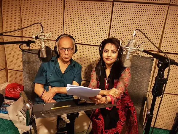 দুজন ব্যক্তি স্টুডিওতে রেকর্ডিং করছেন, পেছনে অডিও প্রোফাইল ও মাইক্রোফোন।. Channel i News - চ্যানেল আই নিউজ