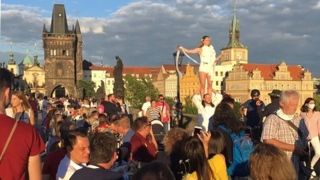 Prague's Old Town Square with crowd, clock tower, and historic buildings. Channel i News - চ্যানেল আই নিউজ