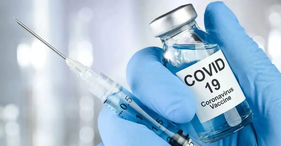 COVID-19 ভ্যাকসিনের জন্য সিরিঞ্জ ও ভ্যাকসিনের বোতল ধরা হাতে. Channel i News - চ্যানেল আই নিউজ