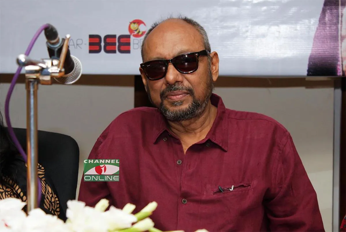 বয়স্ক ব্যক্তি সানগ্লাস পরে, সংবাদ সম্মেলনে বসে. Channel i News - চ্যানেল আই নিউজ