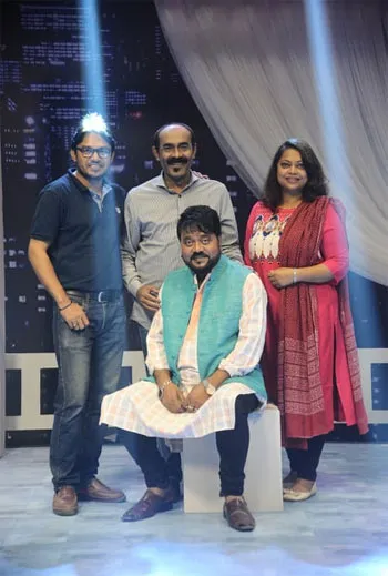 চারজন মানুষ স্টেজে দাঁড়িয়ে হাসিমুখে ছবি তুলছেন. Channel i News - চ্যানেল আই নিউজ