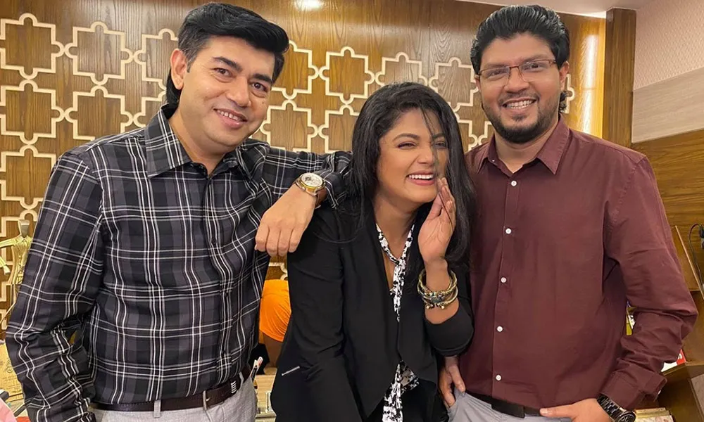 তিনজন মানুষ হাসিমুখে একসঙ্গে ছবি তুলেছেন, পেছনে সুন্দর ডিজাইন করা দেয়াল।. Channel i News - চ্যানেল আই নিউজ