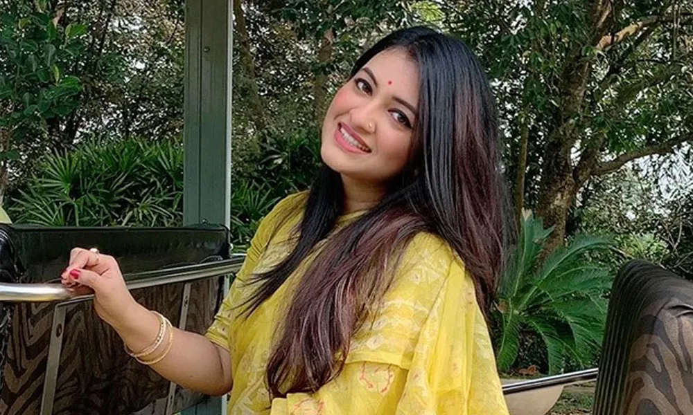 সিঁথি হাসিমুখে বসে আছেন, সবুজ প্রকৃতির পেছনে. Channel i News - চ্যানেল আই নিউজ