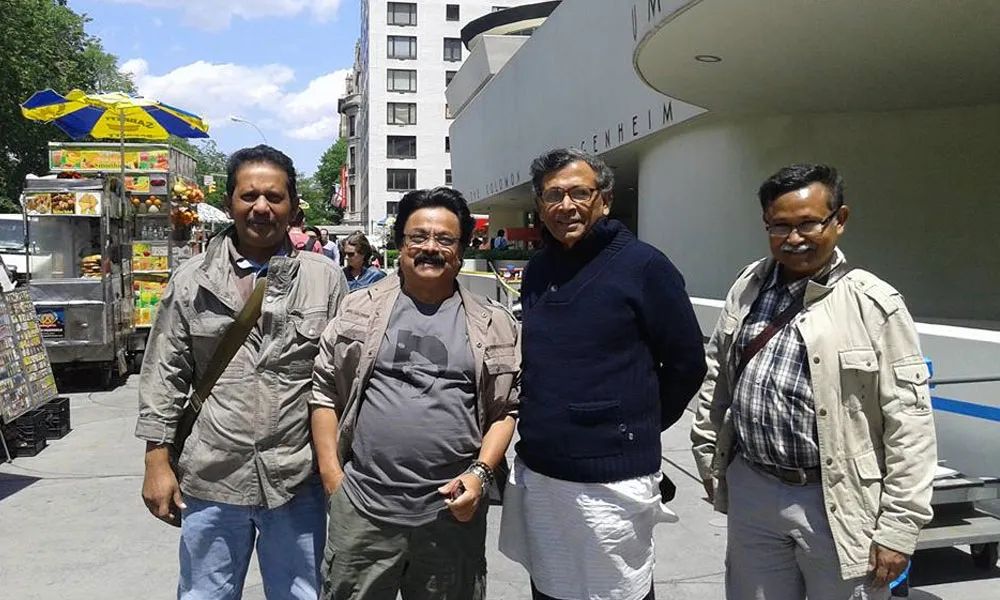 চারজন পুরুষ শহরে হাঁটছেন, একে অপরের সাথে হাসিমুখে।. Channel i News - চ্যানেল আই নিউজ