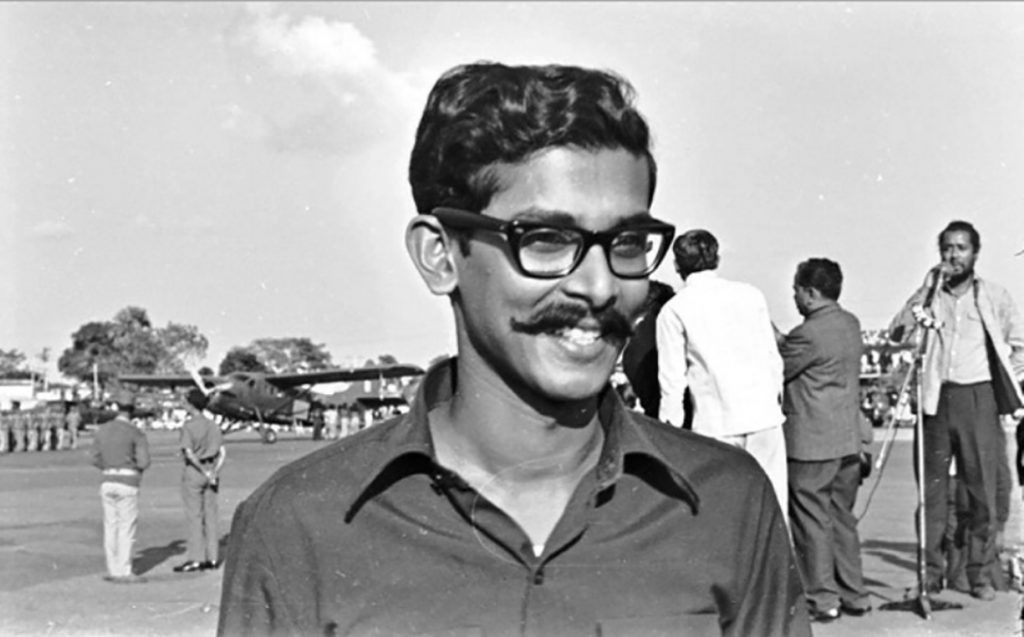 শেখ কামালের কালো-সাদা ছবি, হাসিমুখে, পেছনে খেলাধুলার দৃশ্য. Channel i News - চ্যানেল আই নিউজ