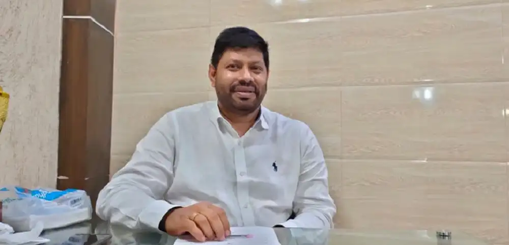 একজন পুরুষ বসে আছেন, হাসছেন, অফিসে বসে ছবি তোলা।. Channel i News - চ্যানেল আই নিউজ
