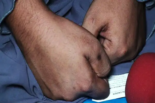 Close-up of clenched fists with a red microphone nearby. Channel i News - চ্যানেল আই নিউজ