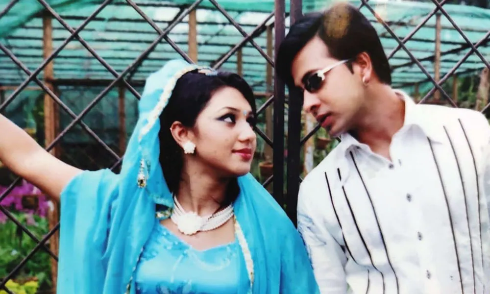 দুটি মানুষ একে অপরের দিকে তাকিয়ে, পেছনে গাছের বেড়া. Channel i News - চ্যানেল আই নিউজ