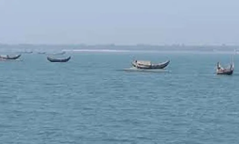 বঙ্গোপসাগরে নৌকা ভাসছে, শান্ত জলরাশি ও দূরবর্তী শহর দৃশ্য. Channel i News - চ্যানেল আই নিউজ