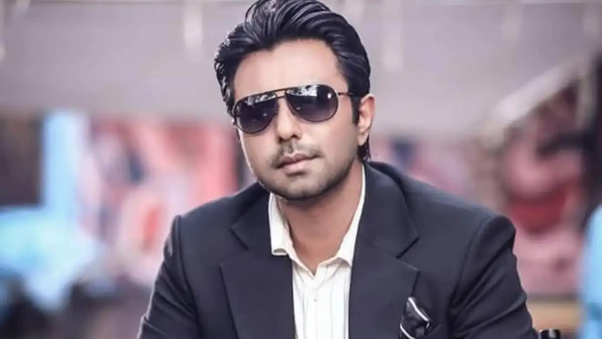 Stylish man wearing sunglasses and black suit in an outdoor setting. Channel i News - চ্যানেল আই নিউজ
