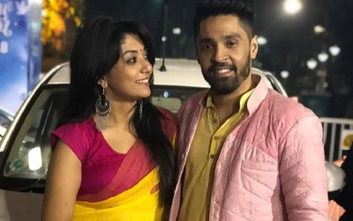দুটি মানুষ হাসিমুখে একসঙ্গে ছবি তুলছেন, পটভূমিতে গাড়ি ও আলো।. Channel i News - চ্যানেল আই নিউজ
