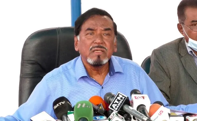 Bangladeshi politician speaking at a press conference with microphones. Channel i News - চ্যানেল আই নিউজ