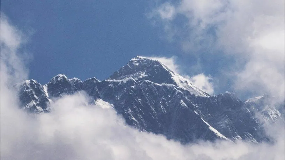 এভারেস্টের শীর্ষে বরফে ঢাকা পর্বতশৃঙ্গ, আকাশে কিছু মেঘ।. Channel i News - চ্যানেল আই নিউজ