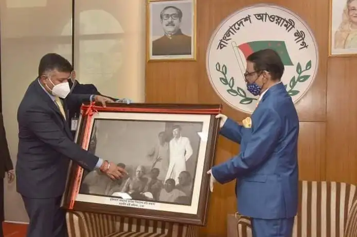 দুই ব্যক্তি ছবি framed ছবি উপস্থাপন করছে, masks পরা. Channel i News - চ্যানেল আই নিউজ