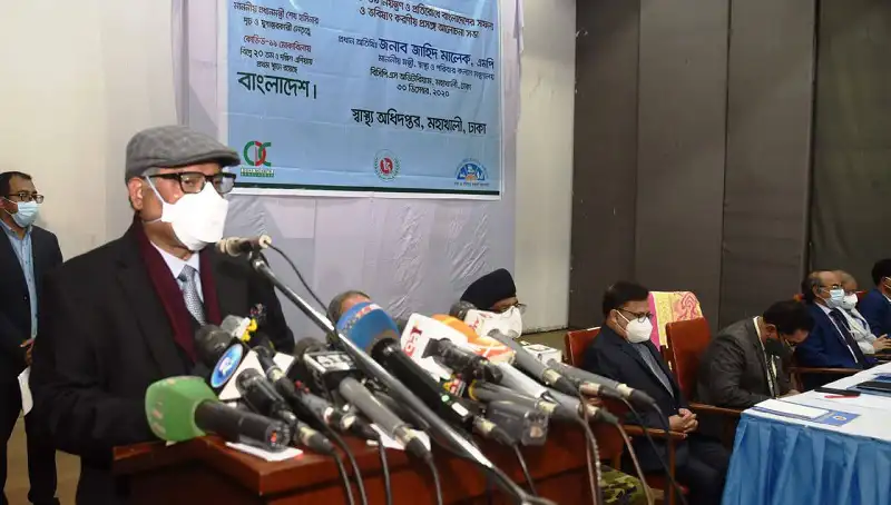 স্বাস্থ্যমন্ত্রী সংবাদ সম্মেলনে বক্তব্য দিচ্ছেন, অন্যান্য কর্মকর্তারা উপস্থিত. Channel i News - চ্যানেল আই নিউজ