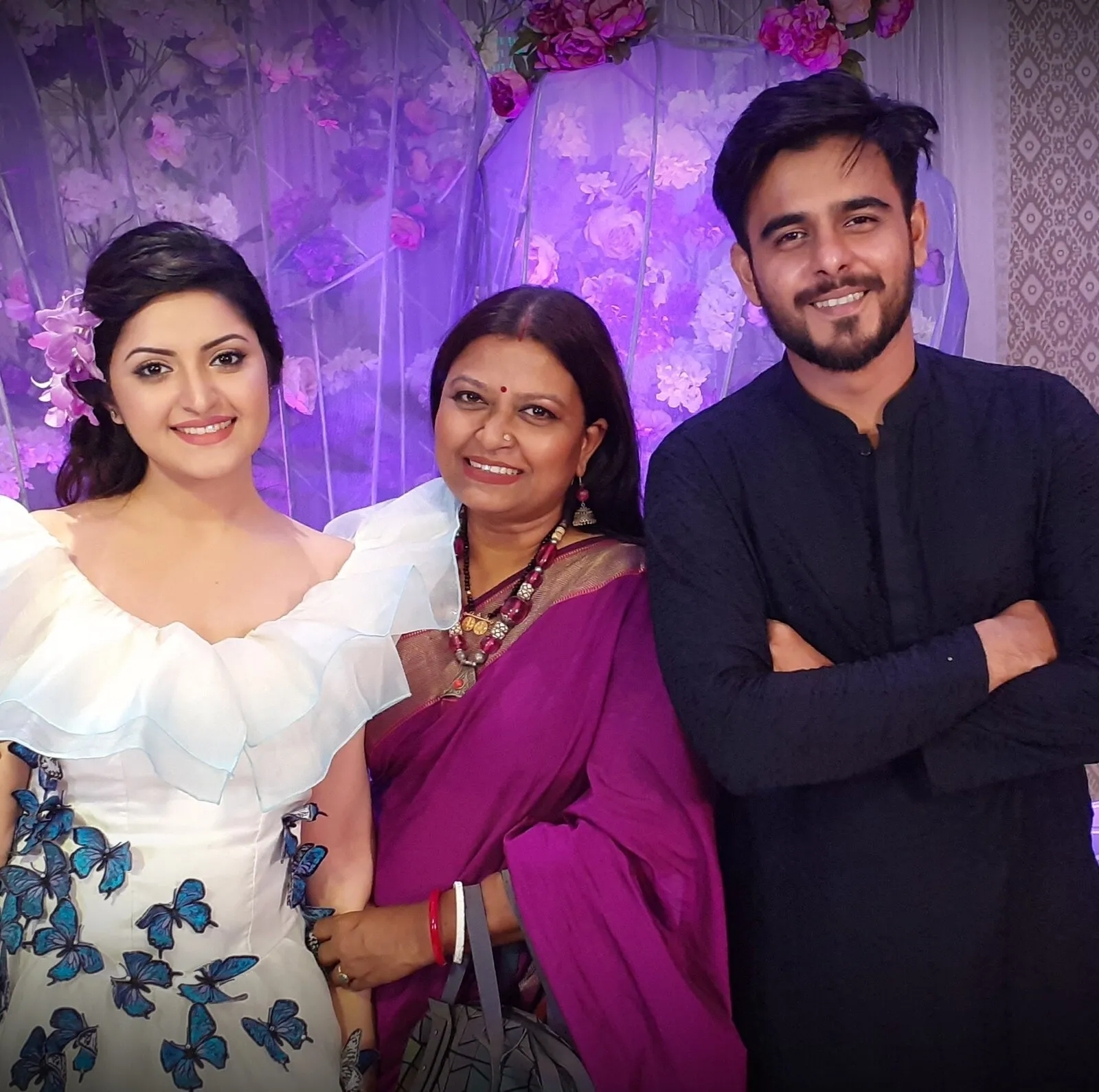 একটি পরিবারের তিনজন সদস্যের ছবি, সবাই হাসিমুখে দাঁড়িয়ে. Channel i News - চ্যানেল আই নিউজ