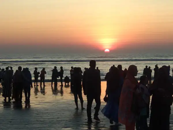 কক্সবাজার সৈকতে সূর্যাস্তের সুন্দর দৃশ্য, মানুষ সমুদ্রের পাশে উপভোগ করছে. Channel i News - চ্যানেল আই নিউজ