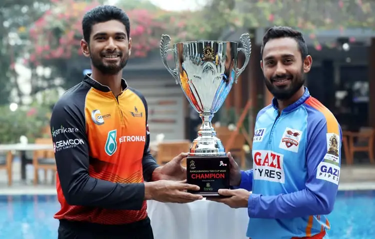 দুটি ক্রিকেট খেলোয়াড় ট্রফি হাতে নিয়ে হাসিমুখে দাঁড়িয়ে. Channel i News - চ্যানেল আই নিউজ