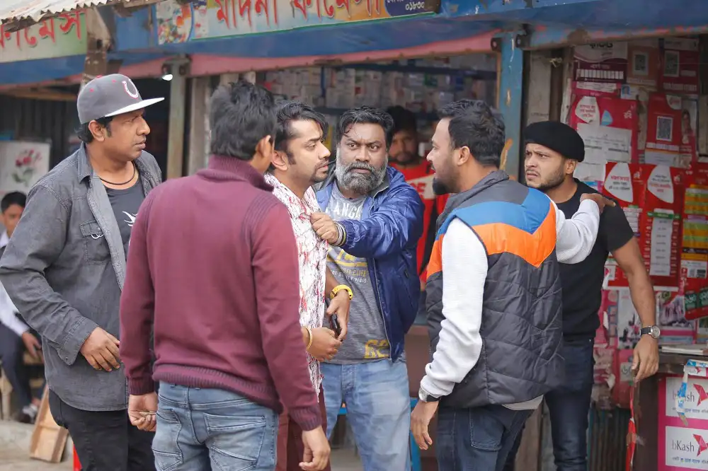 Bangladeshi men engaged in a heated discussion on a busy street. Channel i News - চ্যানেল আই নিউজ