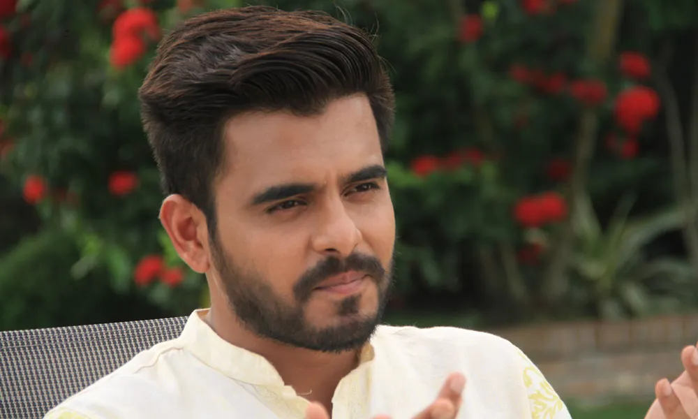 সিয়াম সিনেমা দেখছেন, ক্যামেরার দিকে তাকিয়ে হাসছেন. Channel i News - চ্যানেল আই নিউজ